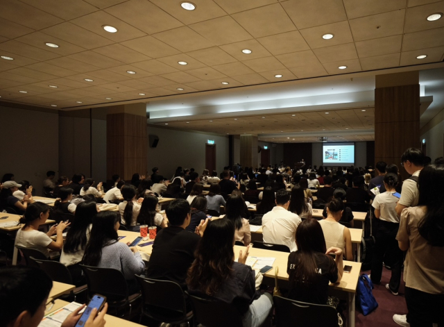 지난해 서울 강남구 코엑스에서 열린 ‘2023 글로벌 탤런트 페어’에 참가한 구직자들이 참여 기업의 채용 설명회를 듣고 있다. 사진제공=KOTRA