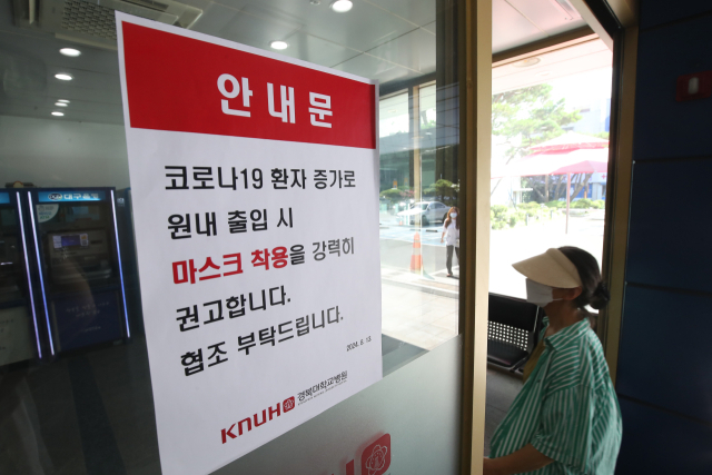 18일 대구 경북대학교병원 출입문에 코로나19 환자 증가로 출입 시 마스크 착용을 강력히 권고하는 안내문이 붙어 있다. 대구=뉴스1