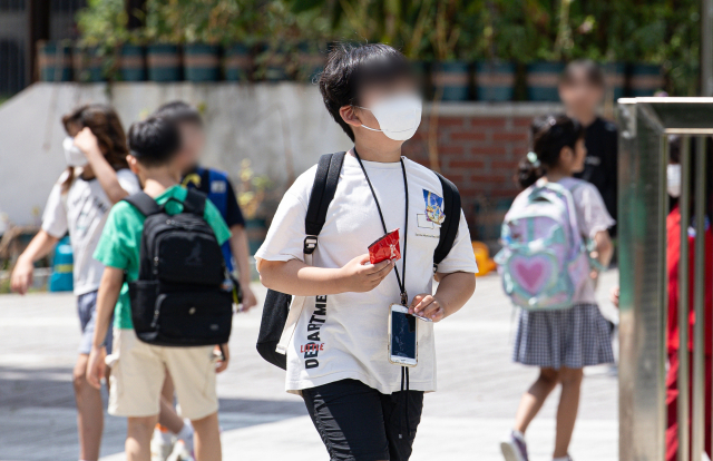 19일 서울의 한 초등학교에서 마스크를 착용한 학생들이 하굣길에 나서고 있다. 뉴스1