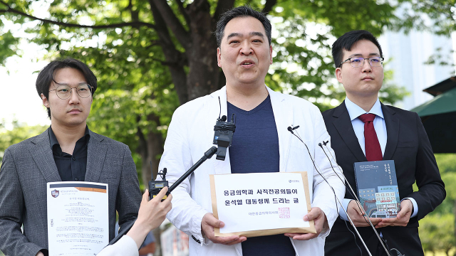 이형민(가운데) 대한응급의학의사회 회장이 5월 서울 용산 대통령실 앞에서 ‘응급의학과 사직 전공의들이 윤석열 대통령께 드리는 글’을 들고 기자회견을 하고 있다. 사진 제공=대한응급의학의사회