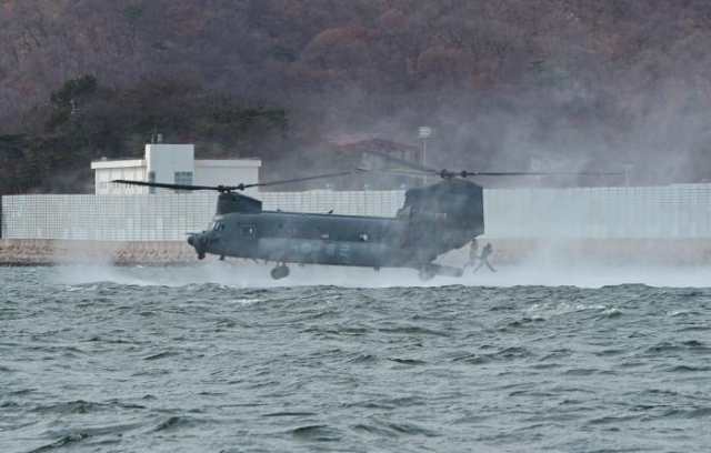 합동 항공구조훈련 중 SSU 구조대원이 공군 HH-47 헬기를 이탈해 바다로 뛰어들고 있다. 사진 제공=해군