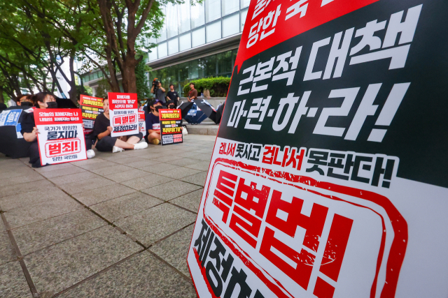 티메프 사태 피해자들이 지난 25일 서울 영등포구 금융감독원 앞에서 검은 우산 집회를 열고 피해자 구제 특별법 제정 등을 촉구하고 있다. 연합뉴스