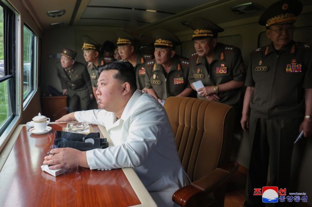 김정은 북한 국무위원장이 27일 제2경제위원회 산하 국방공업기업소들이 생산한 240㎜ 방사포무기체계의 검수시험사격을 참관하고 있다. 연합뉴스