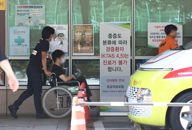 28일 서울의 한 대형 병원 응급실에 도착한 한 환자가 휠체어에 탄 채 이동하고 있다. 연합뉴스