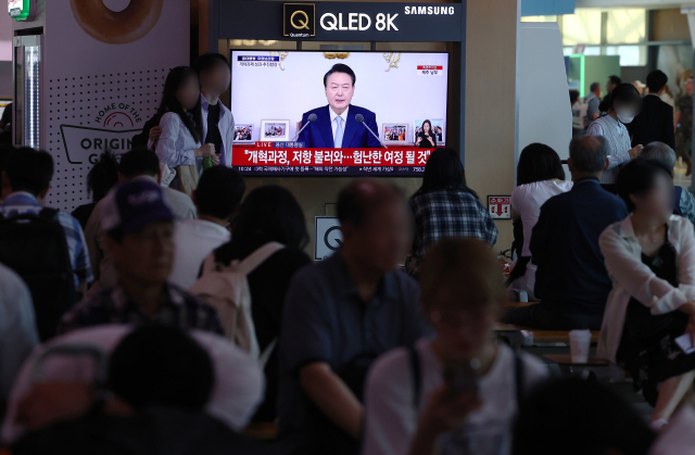 29일 오전 서울 용산구 서울역 대합실에서 시민들이 윤석열 대통령의 국정브리핑 및 기자회견 방송을 시청하고 있다. 연합뉴수