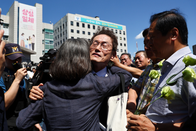 조희연 서울시교육감이 29일 서울시 교육청을 나서며 지지자들과 포옹을 하고 있다. 이날 대법원 3부는 직권남용 권리행사방해 등 혐의로 기소된 조 교육감에게 징역 1년 6개월에 집행유예 2년을 선고한 원심판결을 29일 확정했다. 연합뉴스