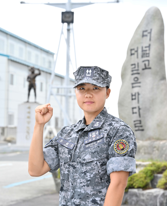 여군 최초로 심해잠수사(SSU)가 된 문희우 대위(진)이 ‘세계최강 SSU’ 동상 앞에서 화이팅 포즈를 취하고 있다. 사진 제공=해군