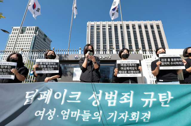 30일 정부서울청사 앞에서 열린 '딥페이크 성범죄 규탄 여성·엄마들의 기자회견'에서 참가자들이 손팻말을 들고 있다. 연합뉴스