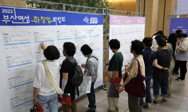 지난해 부산에서 열린 '부산 여성 취·창업 박람회'에서 구직자들이 채용 정보를 살펴보고 있다. 부산=뉴스1