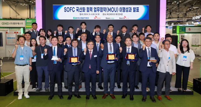 4일 부산 BEXCO에서 열린 SOFC 국산화 협력 이행성과 발표회에서 SK에코플랜트와 한국수력원자력, 블룸에너지, 블룸SK퓨얼셀 관계자들이 기념촬영을 하고 있다(앞줄 왼쪽 3번째부터 김정훈 SK에코플랜트 솔루션BU 대표, 윤상조 한국수력원자력 그린사업본부장, 사티시 치투리(Satish Chitoori) 블룸에너지 COO(Chief Operations Officer), 김세준 블룸SK퓨얼셀 부사장/사진=SK에코플랜트