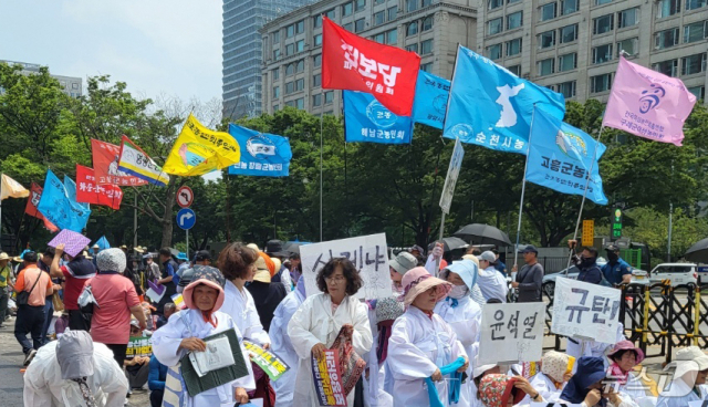 전국농민회총연맹(전농) 등 8개 농민단체 회원들이 7월 4일 오후 서울 여의도 국회 인근에서 열린 7·4 전국농민대회에서 손 피켓 등을 들고 있다.뉴스1