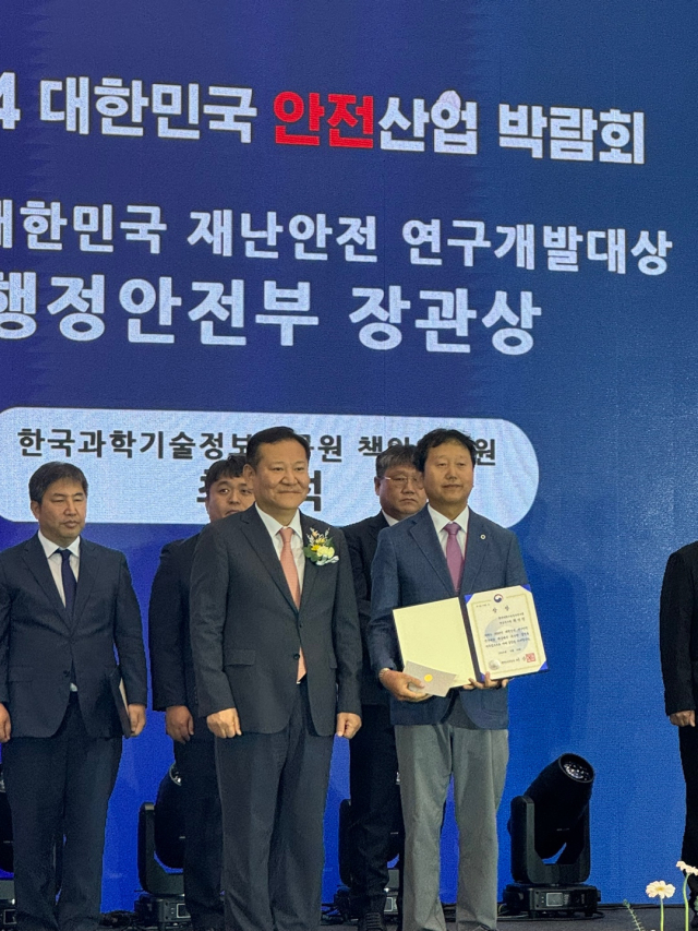 KISTI 최기석(오른쪽) 책임연구원이 이상민(왼쪽) 행정안전부 장관으로부터 ‘2024 대한민국 재난안전 연구개발대상’에서 행정안전부 장관상을 수상하고 기념촬영을 하고 있다. 사진제공=KISTI