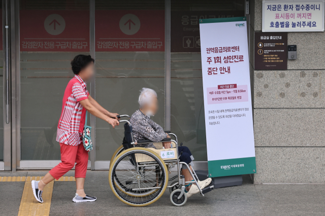 13일 오전 서울 시내 한 대학병원 권역응급의료센터 앞에 주1회 진료를 중단한다는 안내문이 걸려 있다. 연합뉴스