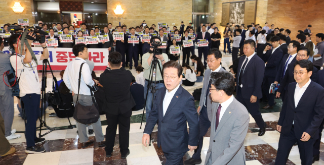 국민의힘 의원들이 19일 오후 ‘김건희 특검법’ 등을 강행 처리하려는 야당을 규탄하는 가운데 더불어민주당의 이재명 대표를 비롯한 의원들이 국회 본회의장으로 들어가고 있다. 연합뉴스