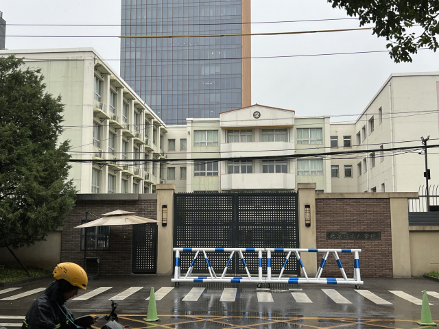 20일 중국 베이징 차오양구에 자리한 일본인학교의 문이 굳게 닫힌 채 한 배달원이 지나가고 있다. 전날 선전에서 괴한이 휘두른 흉기에 찔린 일본 초등학생의 사망 사건에도 일본인학교, 일본대사관 등은 평소처럼 차분한 모습이었지만 사진을 촬영하자 경비원이 곧바로 제지하며 민감하게 반응했다. 사진=김광수 특파원