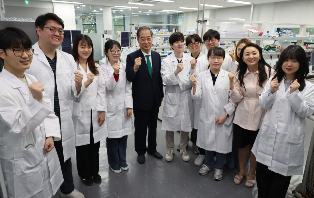 한덕수(왼쪽 네 번째) 국무총리가 27일 서울 관악구 서울대에서 열린 ‘제3차 인재양성전략회의’ 참석에 앞서 유전공학연구소를 방문해 연구원들과 파이팅을 외치고 있다. 연합뉴스