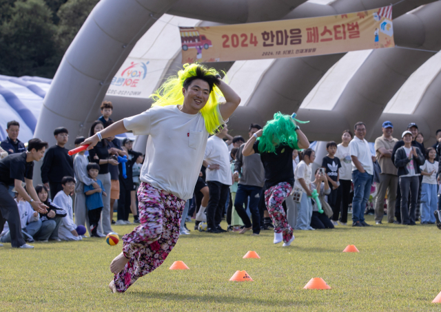 5일 충남 천안 에스원인재개발원에서 열린 오프라인 페스티벌 행사에서 복고풍 복장으로 장애물 계주에 참가한 임직원이 트랙을 돌고 있다. 사진 제공=에스원