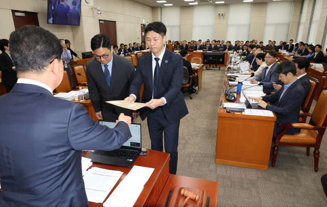 7일 열린 국회 행정안전위원회 국정감사에서 더불어민주당 소속 신정훈 위원장이 대통령 관저 불법증축 및 구조공사와 관련한 증인인 김태영·이승만 21그램 대표를 출석시키기 위한 동행명령장을 발부하고 있다. 연합뉴스