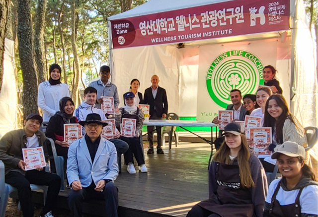 영산대학교 웰니스관광연구원장인 정구점 교수가 외국인 유학생들과 최근 열린 '영덕국제H웰니스페스타'에 참석해 기념촬영을 하고 있다. 사진제공=영산대