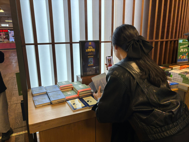 한강 작가가 노벨문학상을 수상한 10일 오후 광화문 교보문고를 찾은 한 손님이 한강 작가의 책을 보고 있다. 정다은 기자