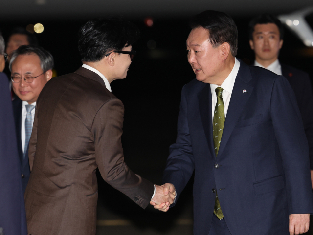 윤석열 대통령이 11일 성남 서울공항에서 필리핀, 싱가포르 국빈 방문 및 라오스 아세안 정상회의를 마치고 귀국하며 마중 나온 한동훈 국민의힘 대표와 악수하고 있다. 연합뉴스