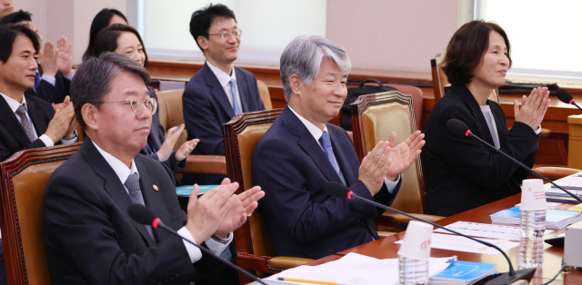 이종석 헌법재판소장이 11일 오전 국회 법제사법위원회의 헌법재판소 등에 대한 국정감사에서 정청래 위원장의 제안으로 위원, 증인들과 함께 한강의 노벨문학상 수상을 축하하는 박수를 치고 있다. 왼쪽부터 김정원 헌법재판소 사무처장, 이종석 헌법재판소장, 지성수 헌법재판연구원장. 연합뉴스