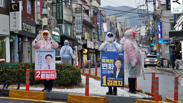 10·16 부산 금정구청장 보궐선거가 치러지는 금정구 서동 미로시장 앞 삼거리에서 김경지 더불어민주당 후보와 윤일현 국민의힘 후보의 선거운동원이 지지를 호소하고 있다. 부산=정상훈 기자