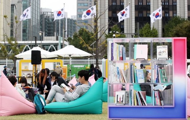 13일 오후 휴일을 맞아 서울 종로구 광화문광장 '서울야외도서관 광화문책마당'을 찾은 시민들이 빈백 소파에 기대어 독서 삼매경에 빠져 있다. 뉴스1