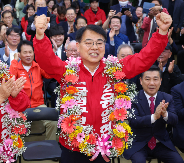 윤일현 국민의힘 금정구청장보궐선거 후보가 16일 오후 부산 금정구 선거사무소에서 당선이 유력해지자 꽃다발을 목에걸고 환호하고 있다. 연합뉴스