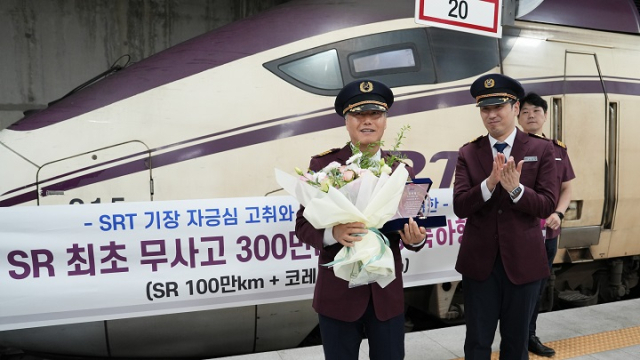 홍석의(왼쪽) 기장이 수서역에서 열린 무사고 100만㎞ 달성 축하행사에서 꽃다발을 받고 기념촬영을 하고 있다. 사진제공=에스알