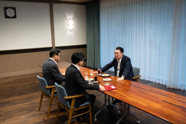 윤석열 대통령이 21일 서울 용산 대통령실 앞 파인그라스에서 한동훈 국민의힘 대표를 만나 대화하고 있다. 이 자리에는 정진석 대통령 비서실장이 배석했다. 연합뉴스