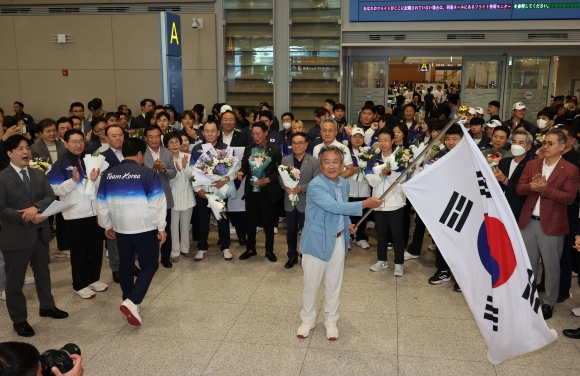 이기흥 대한체육회장이 8월 13일 인천국제공항 제2여객터미널 입국장 로비에서 열린 ‘2024 파리 올림픽’ 대한민국 선수단 해단식에서 태극기를 흔들고 있다. 당초 인근 대형 그레이트홀에서 해단식을 열기로 예정됐지만 체육회는 이를 취소하고 약식으로 진행해 선수단 홀대 논란을 불렀다. 연합뉴스