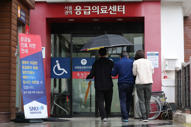 22일 오전 내원객들이 진료 지연 안내문이 놓인 서울 한 대형병원 응급의료센터로 들어서고 있다. 연합뉴스