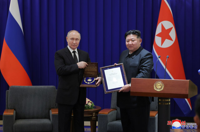 김정은(오른쪽) 북한 국무위원장이 지난 6월 19일 평양에서 열린 북러 정상회담에서 블라디미르 푸틴 러시아 대통령에게 최고훈장인 ‘김일성훈장’을 수여하고 있다. 연합뉴스