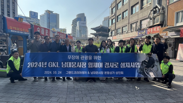 GKL 임직원들이 지난 24일 서울 남대문시장에 교통약자를 위한 경사로를 기증하고 있다. 사진 제공=GKL