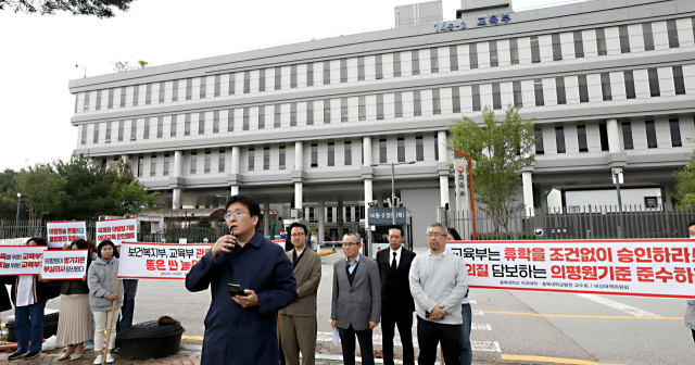 전국의과대학교수비상대책위원회 소속 교수들이 21일 정부세종청사 교육부 앞에서 집회를 열고 정부의 의대증원과 대학교육 자율성 훼손을 규탄하는 구호를 외치고 있다. 세종=뉴스1