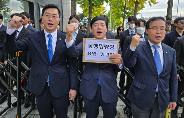 국회 법제사법위원회 소속 장경태(왼쪽부터), 이성윤, 이건태 더불어민주당 의원이 21일 오후 서울 용산구 대통령 관저 인근에서 김건희 여사에 대한 동행명령장을 전달하기 위해 이동하던 중 경찰에 막히자 구호를 외치고 있다. 뉴스1