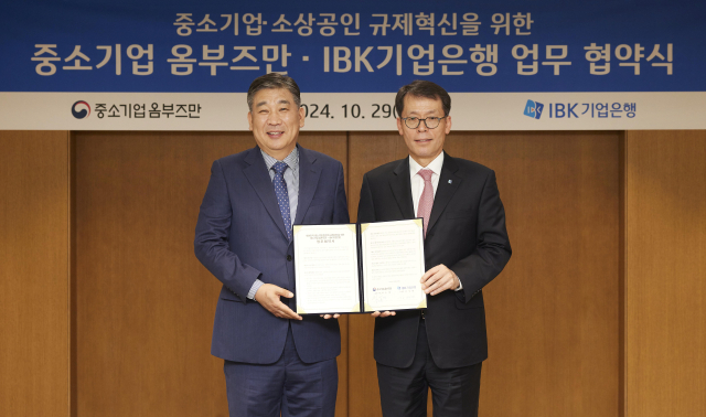 김성태(오른쪽) IBK기업은행장과 최승재 중소기업 옴부즈만이 29일 서울 중구 기업은행 본점에서 중소기업·소상공인 규제혁신을 위한 업무협약 후 기념 촬영을 하고 있다. 사진 제공=IBK기업은행