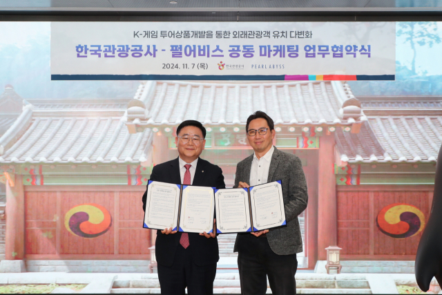 이학주(왼쪽) 한국관광공사 국제관광본부장이 7일 펄어비스 본사에서 김경만 펄어비스 서비스사업부분 이사와 함께 게임 투어 상품 개발을 위한 공동 마케팅 업무협약을 체결한 뒤 협약서를 들어보이고 있다. 사진 제공=한국관광공사