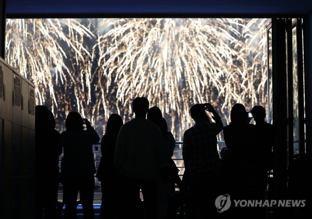 부산 시민들이 9일 수영구 광안리 해수욕장에서 열린 부산불꽃축제에서 사진을 찍고 있다. 사진=연합뉴스