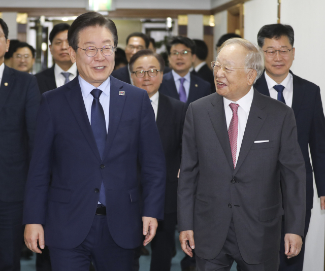 이재명(왼쪽) 더불어민주당 대표가 11일 오전 서울 마포구 경총회관에서 손경식 한국경영자총협회 회장과 대화하며 이동하고 있다. 연합뉴스