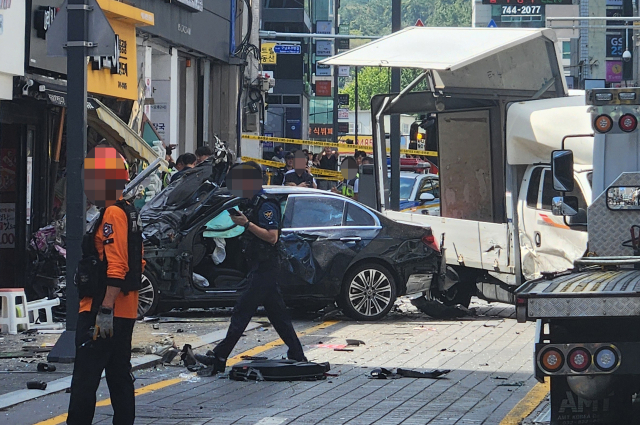 지난 9월12일 오후 부산 해운대구 한 도로에서 벤츠 승용차가 인도로 돌진해 정차해있던 트럭과 보행자 2명을 치고 한 점포를 충격한 뒤 멈춰 서 있다. 연합뉴스