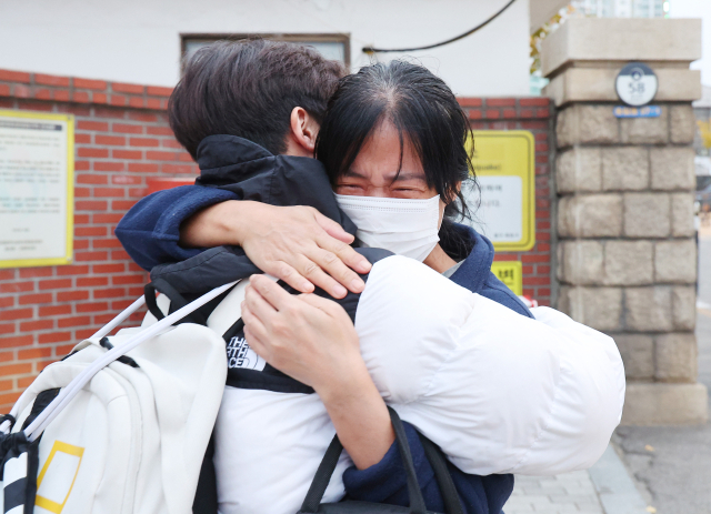 14일 오전 인천 동구 동산고등학교에 마련된 고사장 앞에서 한 학부모가 수험생 자녀를 안아주며 응원하고 있다. 연합뉴스