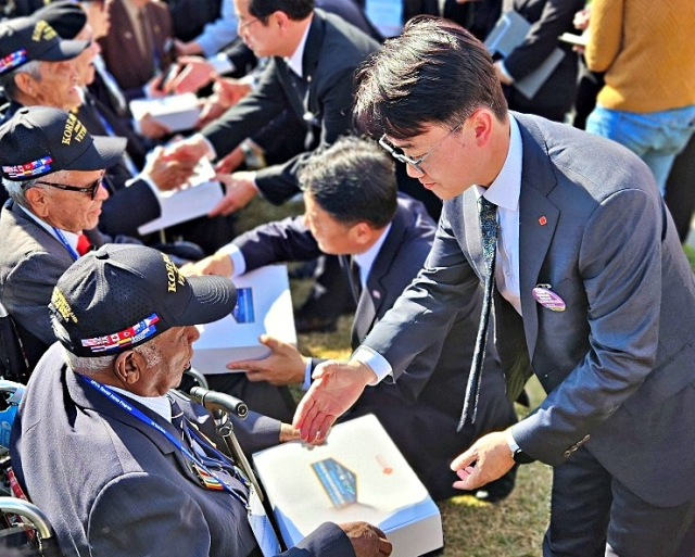 부산 유엔기념공원에서 11일 열린 ‘턴 투워드 부산(Turn Toward Busan)’ 행사에서 위세량(오른쪽) 롯데웰푸드 커뮤니케이션부문장이 유엔 참전용사에게 빼빼로가 포함된 감사 키트를 전달하고 있다. 사진 제공=롯데웰푸드