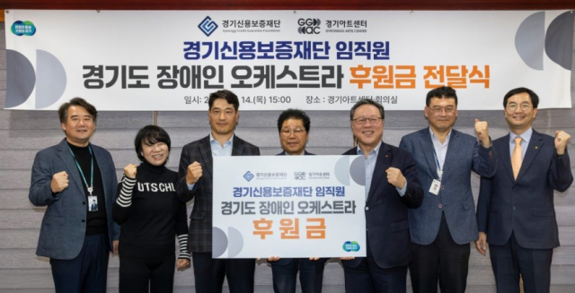 시석중 경기신용보증재단 이사장(왼쪽에서 세번째)이 14일 경기아트센터에서 경기도 장애인 오케스트라에 임직원들이 모은 1000만 원의 후원금을 전달하고 기념촬영을 하고 있다. 사진 제공=경기신용보증재단