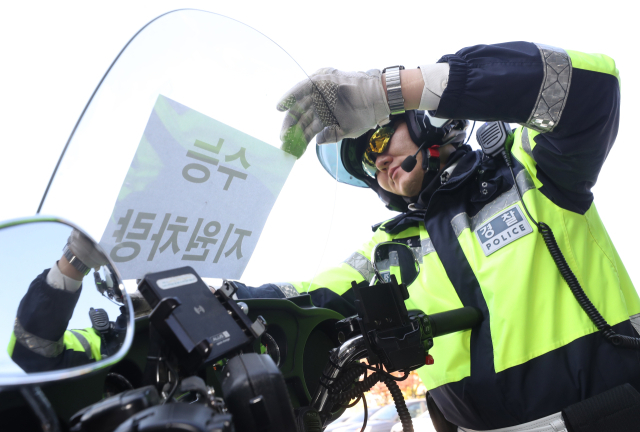 11일 오전 경기 수원시 영통구 수원남부경찰서에서 교통안전계 경찰관들이 수능 당일 시험장 주변 특별 교통관리에 투입될 지원차량에 안내문을 부착하고 있다. 뉴스1