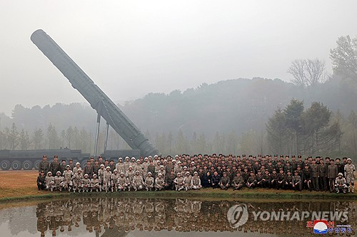 지난달 31일 북한이 신형 대륙간탄도미사일(ICBM) '화성포-19형' 시험발사를 한 뒤 관계자들이 단체 사진을 찍고 있다. 연합뉴스