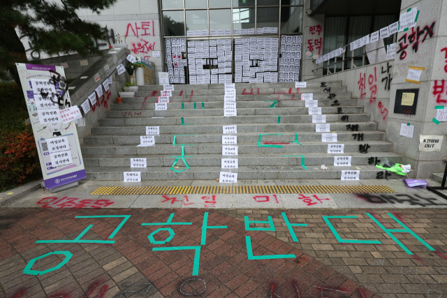 14일 서울 성북구 동덕여대 캠퍼스에 남녀 공학 전환을 반대하는 학생들이 래커, 테이프 등으로 문구를 표시해놓은 모습. 연합뉴스