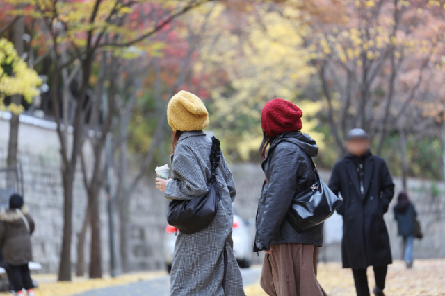 쌀쌀한 날씨를 보인 17일 두꺼운 복장에 털모자를 쓴 외국인들이 서울 중구 덕수궁 돌담길을 지나고 있다. 연합뉴스