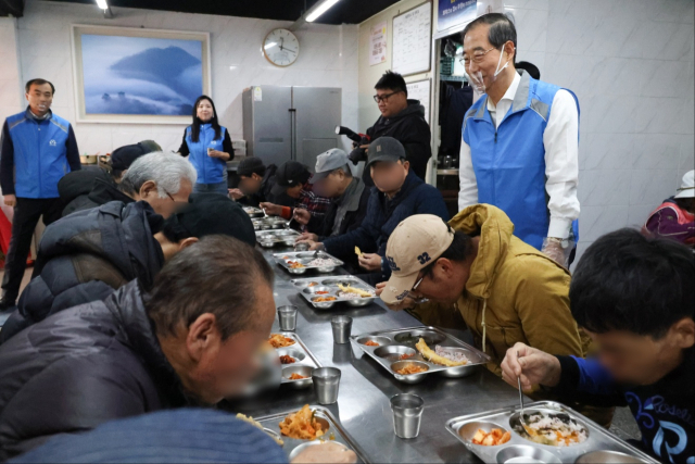 한덕수(오른쪽) 국무총리가 19일 서울 영등포구 쪽방촌 인근 ‘토마스의 집’에서 배식 봉사활동을 하고 있다. 한 총리는 “취약 계층이 겨울을 잘 견딜 수 있도록 정부가 노력할 것”이라고 말했다. 사진제공=총리실